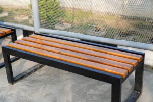 A,Wooden,Bench,With,A,Black,Metal,Frame,Sits,Outside